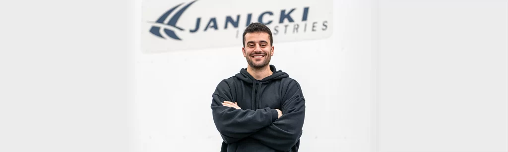 Cesar, Project Engineer, poses with Janicki sign
