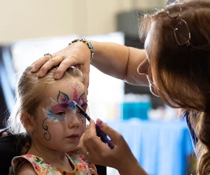 A young girl gets her face painted