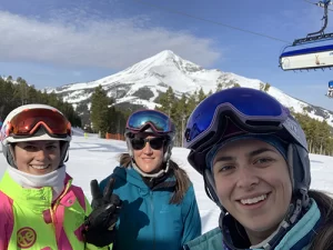 Madison and her family pose on a mountain skiing