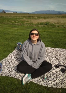 Serenity sitting on a blanket at a park