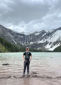 Branton standing in front of mountains on a hike