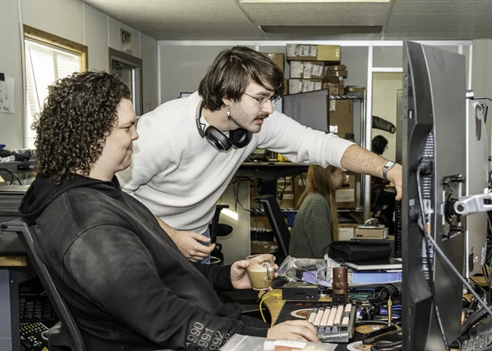 Ben points to something on coworker's screen