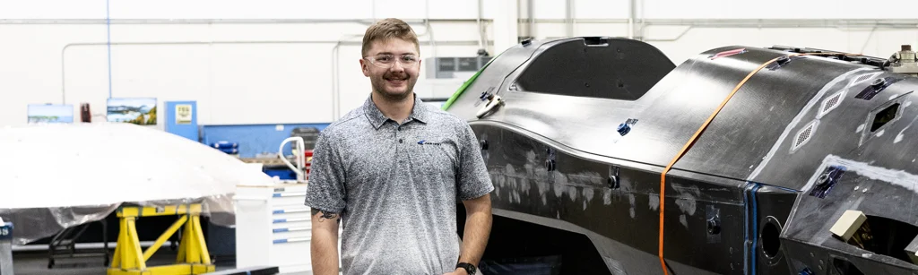 Peter, an engineer, stands with aersoapce assembly